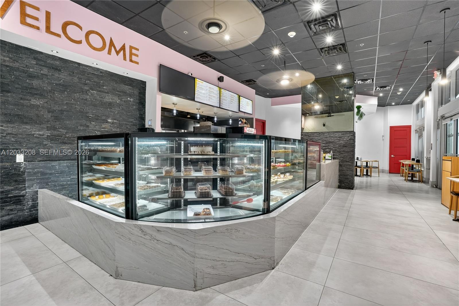 A bakery interior features a large glass display case, stone accent walls, and tiled flooring — 9059 SW 73rd Ct, Miami FL 33156, MIAMI, FL