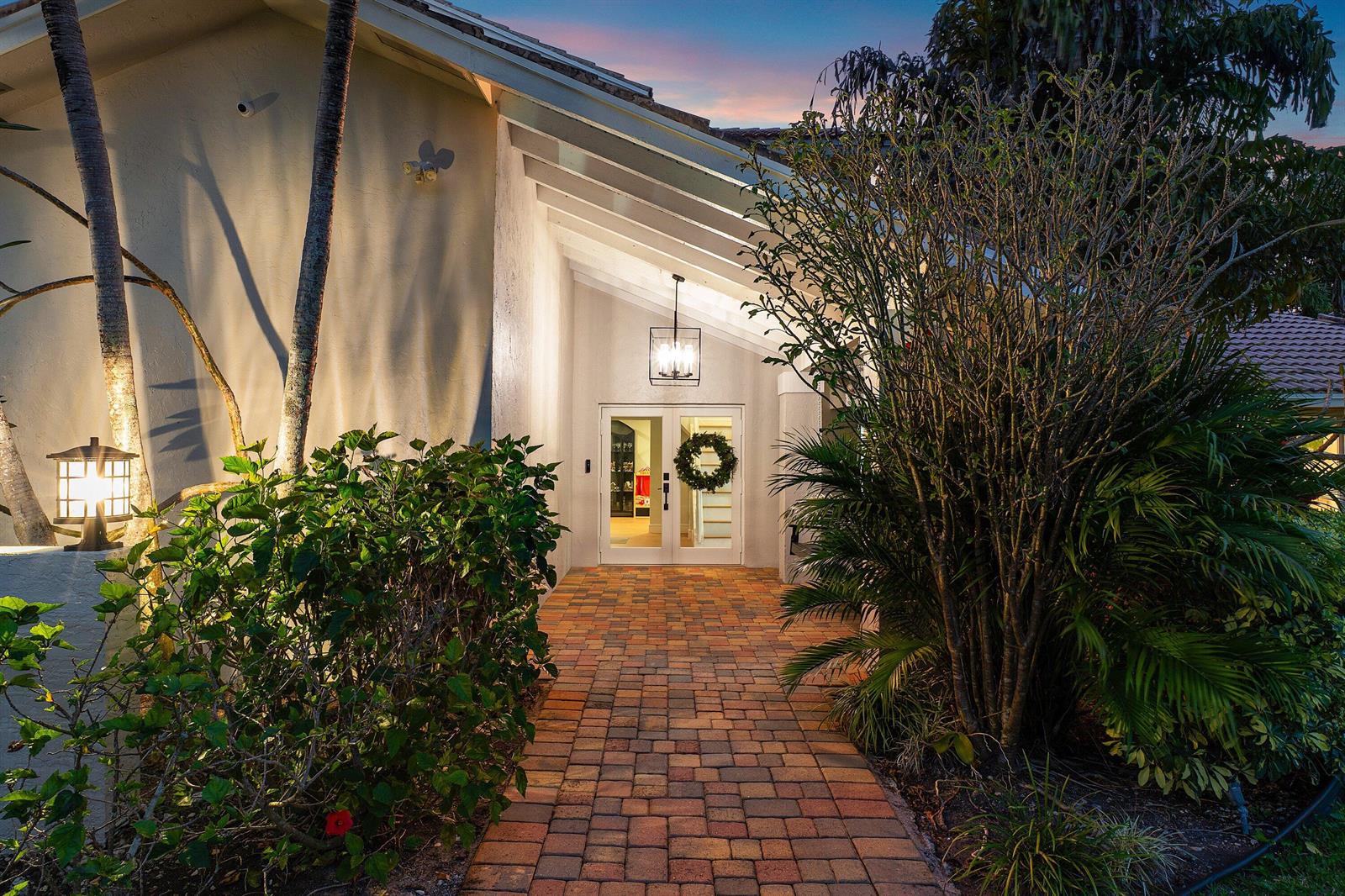 A brick walkway leads to the white double front doors of a house at dusk — 10893 Gleneagles Road, Boynton Beach FL 33436, BOYNTON BEACH, FL