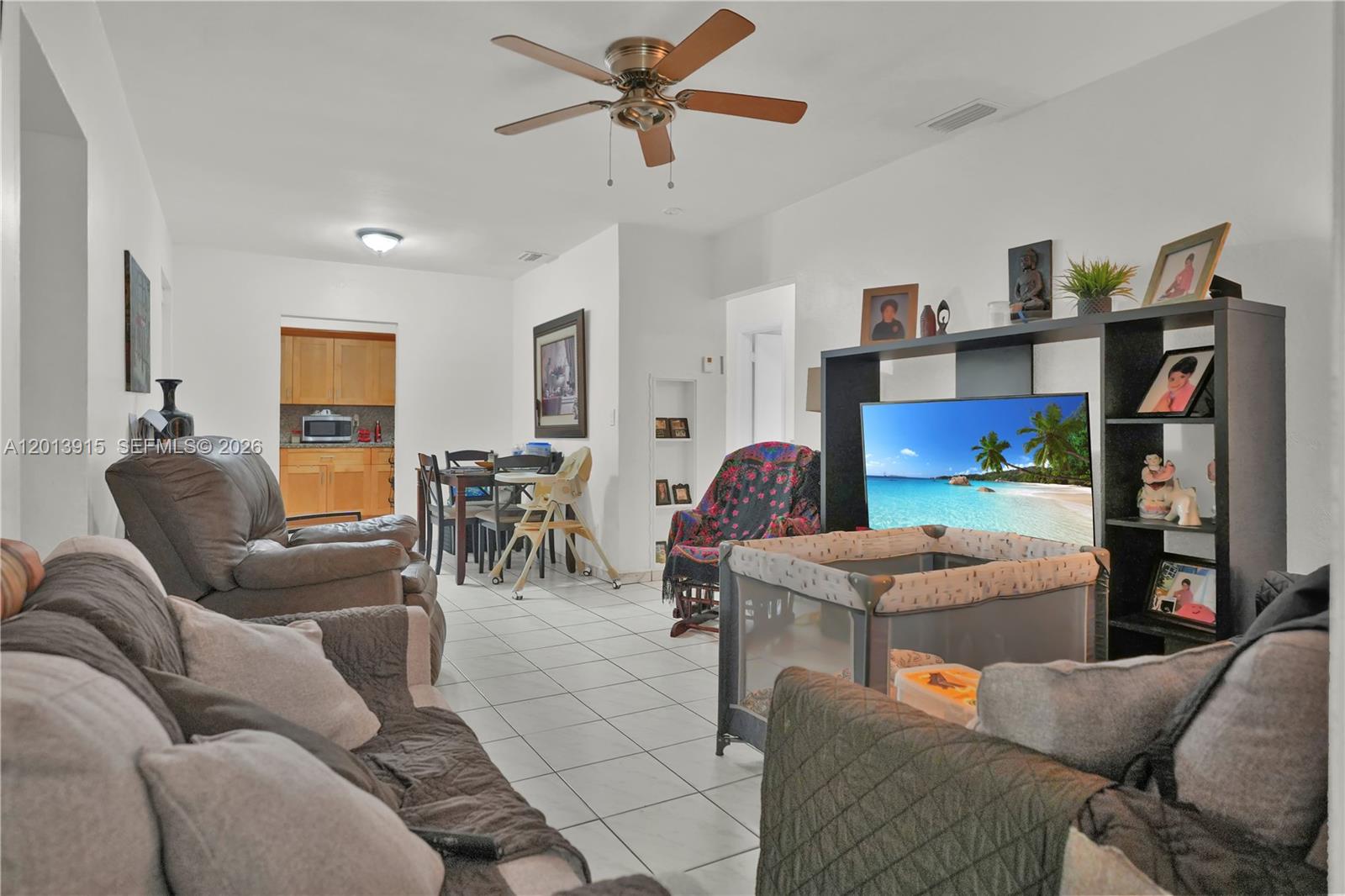 A living room with tiled floors, a ceiling fan, and an open dining area — 201 NW 25th Ave, Miami FL 33125, MIAMI, FL