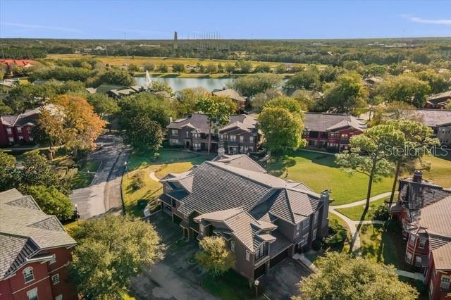 An aerial view shows multi-story residential buildings with dark roofs surrounded by trees and grass — 246 VILLA DI ESTE TERRACE UNIT 200, LAKE MARY, FL