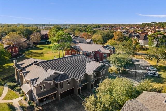 An aerial view shows a multi-story apartment building with a dark roof and surrounding landscaping — 246 VILLA DI ESTE TERRACE UNIT 200, LAKE MARY, FL