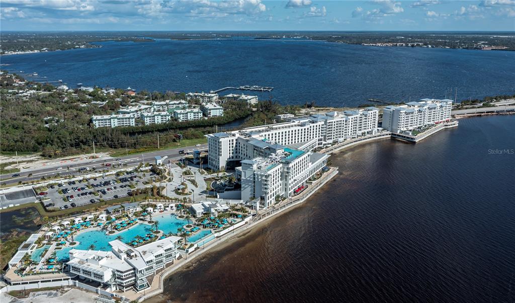 An aerial view shows a large waterfront hotel complex with a pool area and parking — 3570 TAMIAMI TRAIL, PORT CHARLOTTE, FL