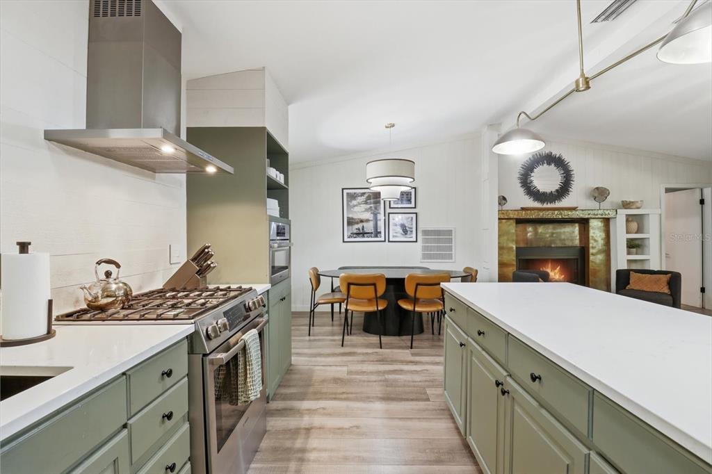 A kitchen with sage green cabinets, a large white island, and an adjacent dining area — 8952 W WHITE DOGWOOD DRIVE, HOMOSASSA, FL