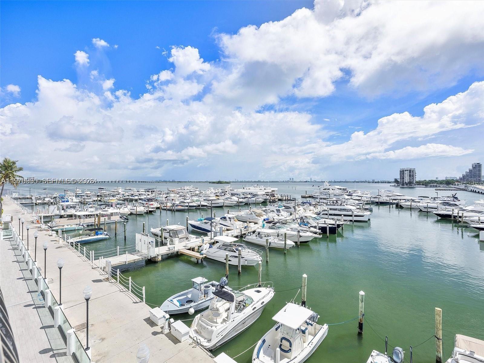A high-angle view of a marina filled with numerous boats docked along wooden piers — 555 NE 15th St # 408, Miami FL 33132, MIAMI, FL
