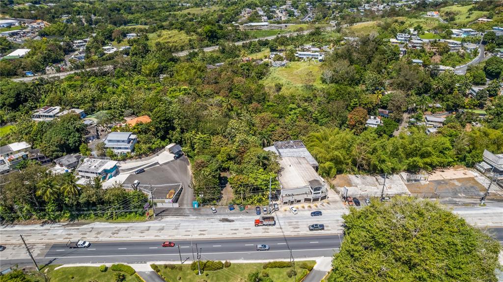 An aerial view shows a commercial building and parking lot adjacent to a multi-lane highway — PR-1 KM 20.4, GUAYNABO, PR