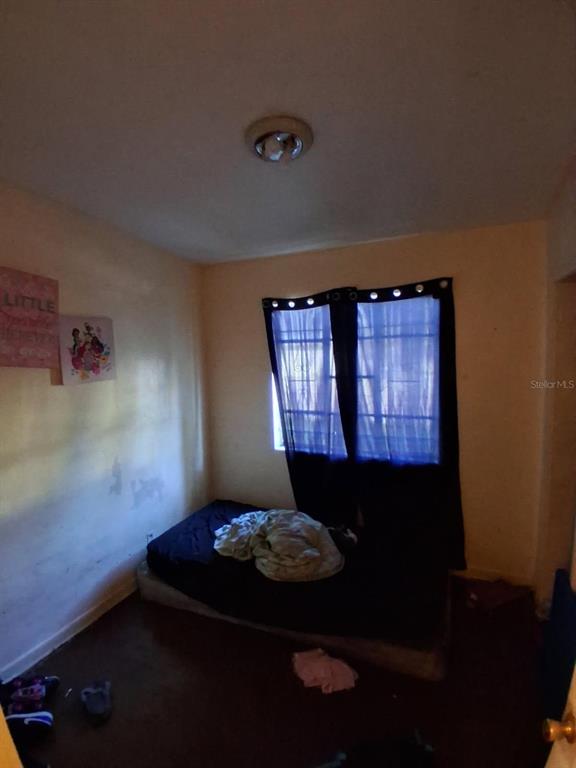 A bedroom features a mattress on the floor, dark curtains, and light-colored walls — 2748 W 45TH STREET, JACKSONVILLE, FL
