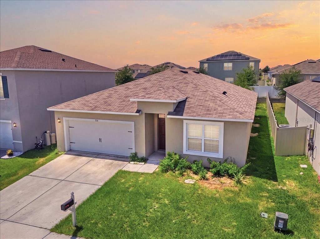 An exterior view of a single-story suburban house with a two-car garage and lawn — 750 LAFAYETTE LANE, HAINES CITY, FL