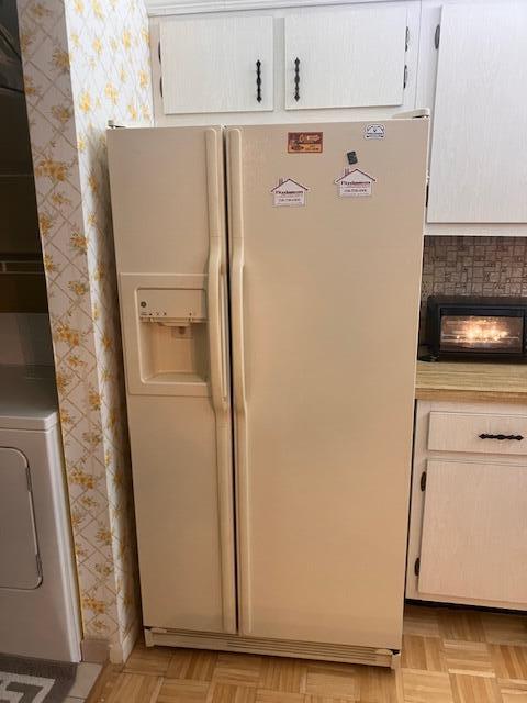 A beige side-by-side refrigerator stands in a kitchen with light wood cabinets and flooring — 102 Lake Pine Circle # 2, FL 33463, FL
