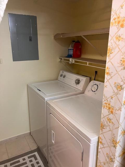 A laundry closet contains a white washer and dryer beneath a shelf and electrical panel — 102 Lake Pine Circle # 2, FL 33463, FL