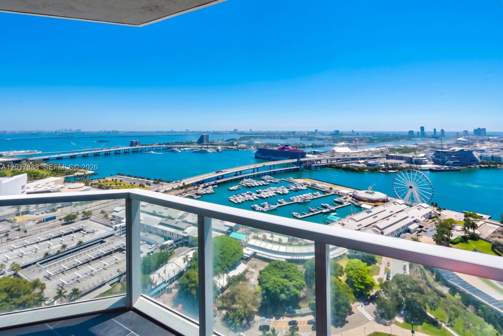 A high-rise balcony overlooks a marina, a Ferris wheel, a cruise ship, and a bridge — 244 Biscayne Blvd # 3602, Miami FL 33132, MIAMI, FL