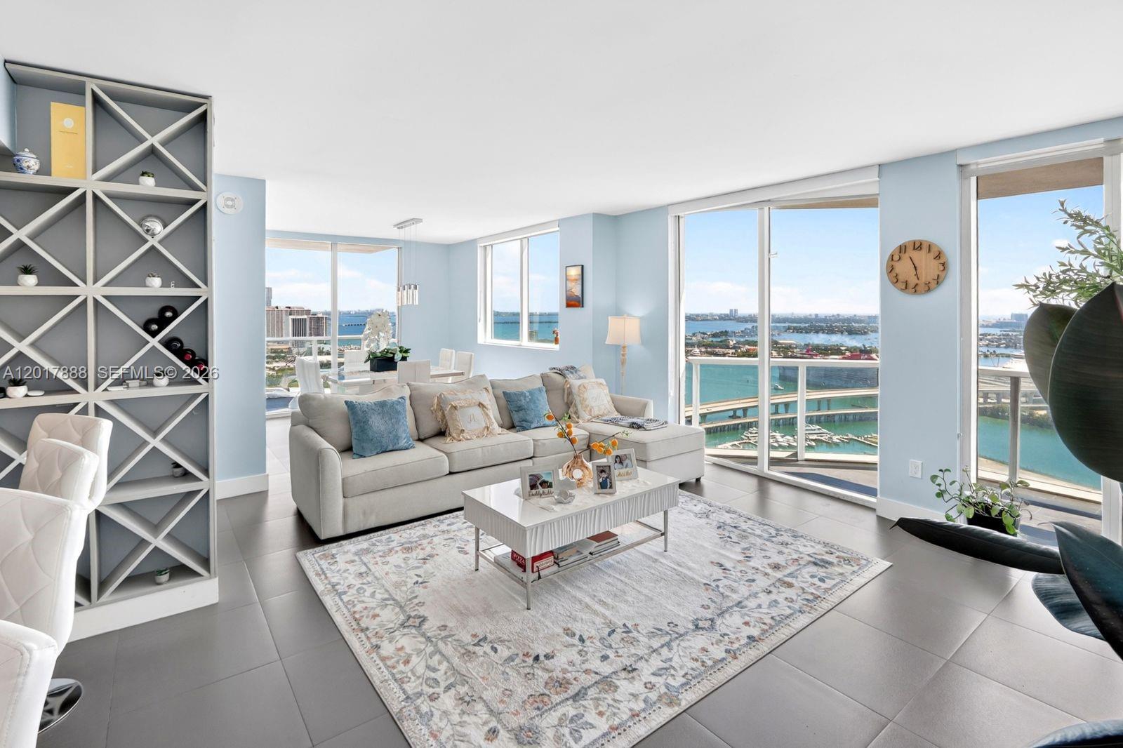 A living room with a sectional sofa, area rug, and floor-to-ceiling windows overlooking water — 244 Biscayne Blvd # 3602, Miami FL 33132, MIAMI, FL