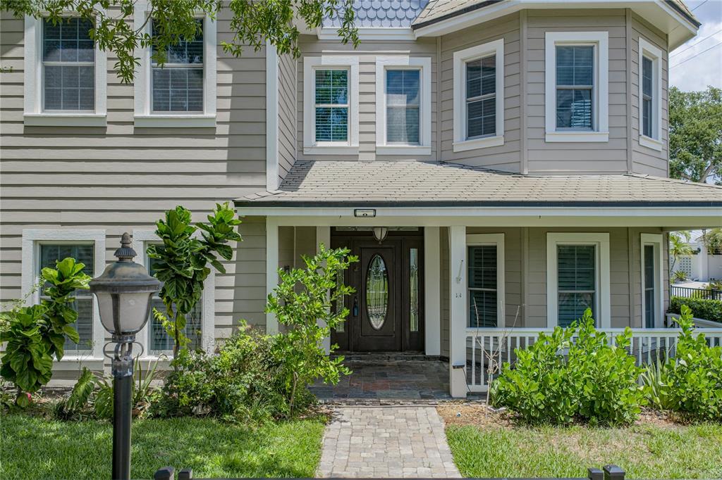 A two-story house with beige siding, a front porch, and a stone walkway — 3001 W SAN RAFAEL STREET, TAMPA, FL