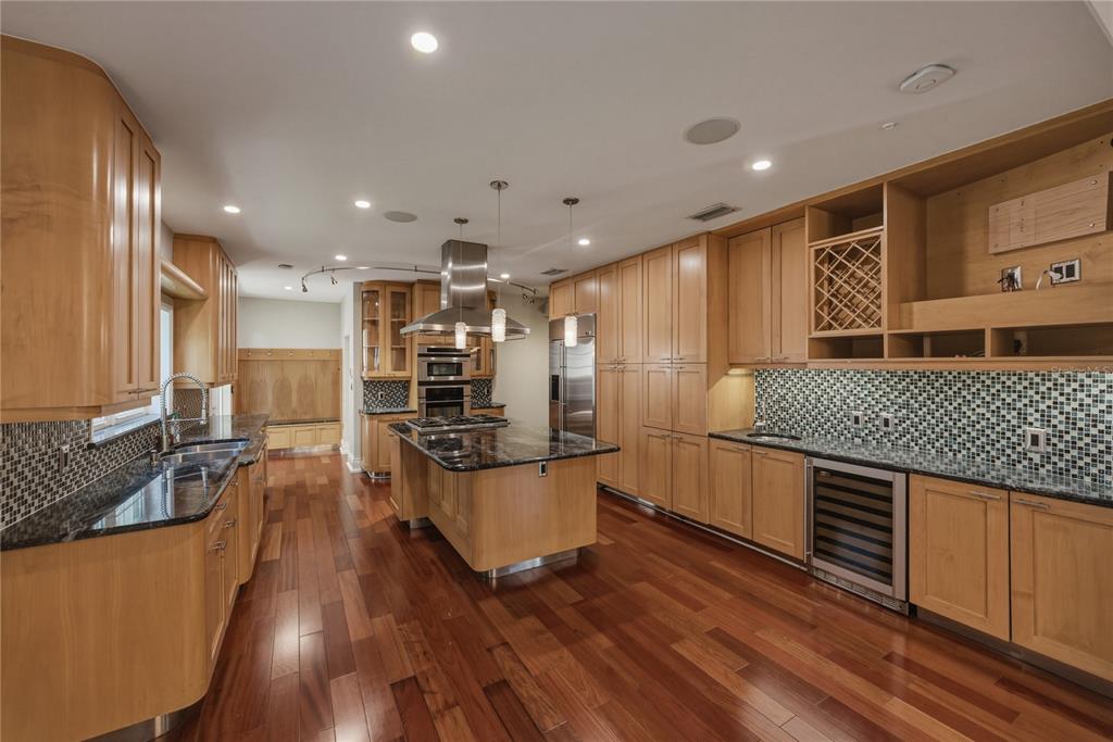 An empty dining room with hardwood floors, crown molding, and a modern chandelier — 3001 W SAN RAFAEL STREET, TAMPA, FL