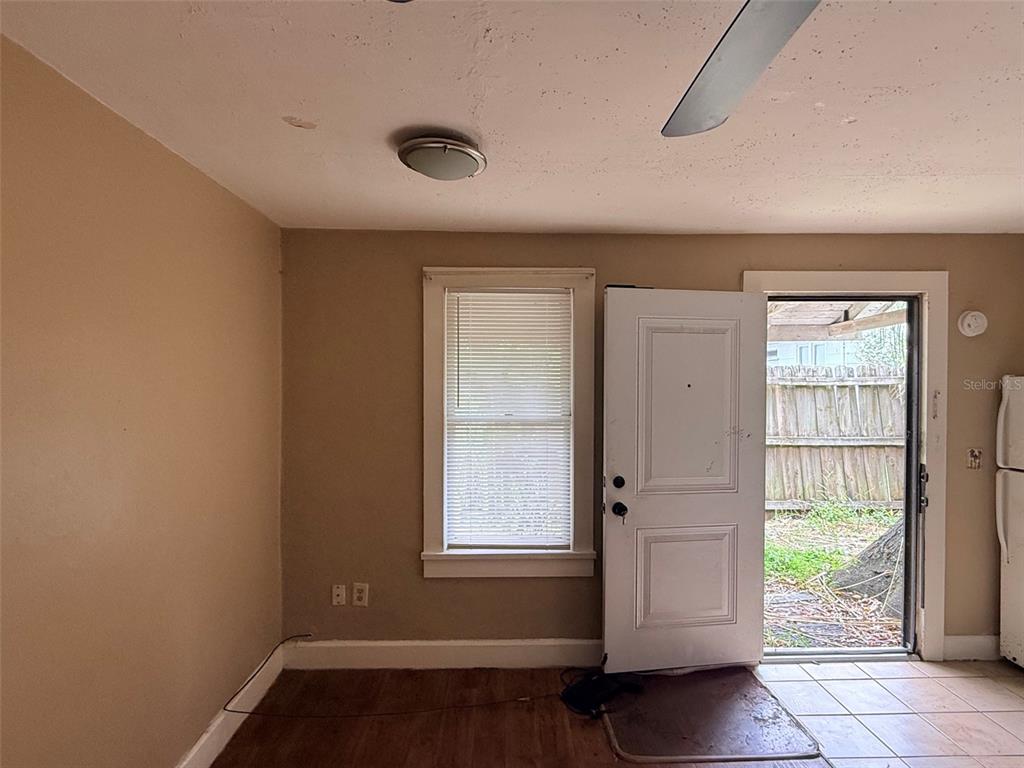 A room with tan walls, a window with blinds, and an open door to a yard — 1648 27TH AVENUE N UNIT 2, ST PETERSBURG, FL
