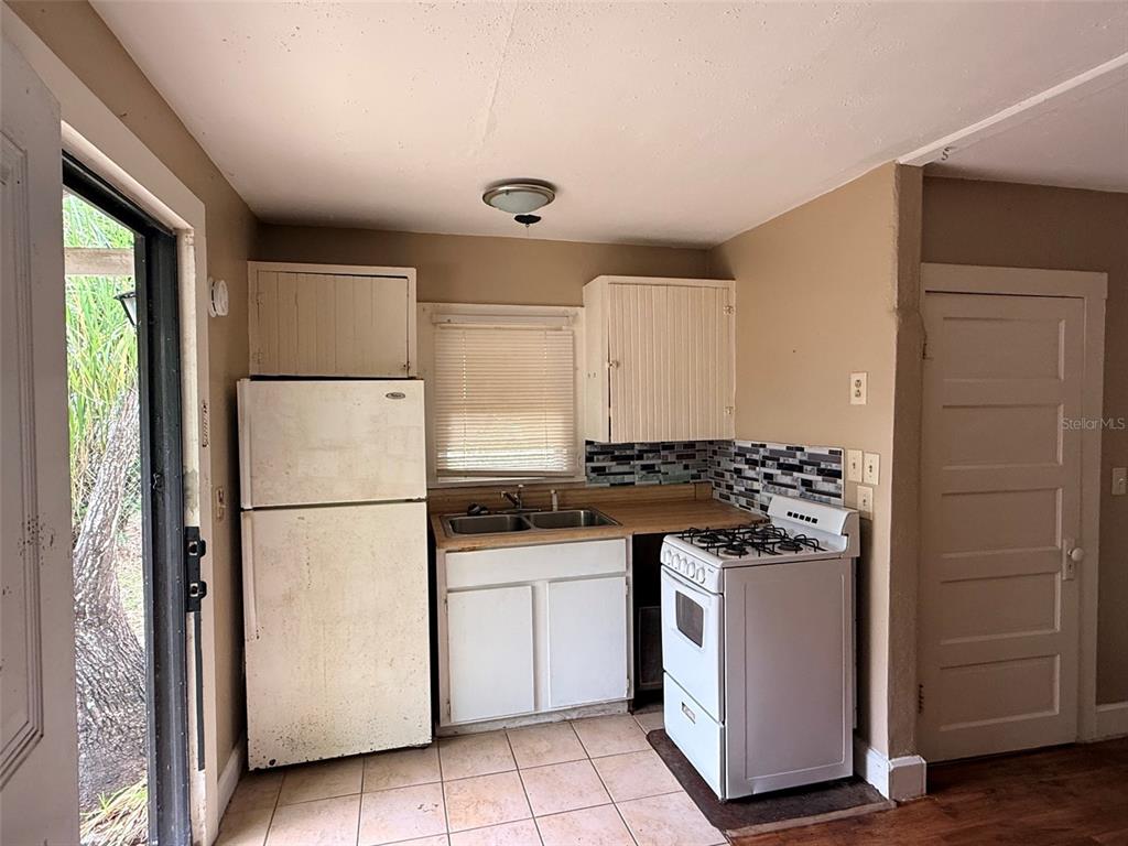 A small kitchen features white appliances, wood-look laminate countertops, and a tiled floor — 1648 27TH AVENUE N UNIT 2, ST PETERSBURG, FL