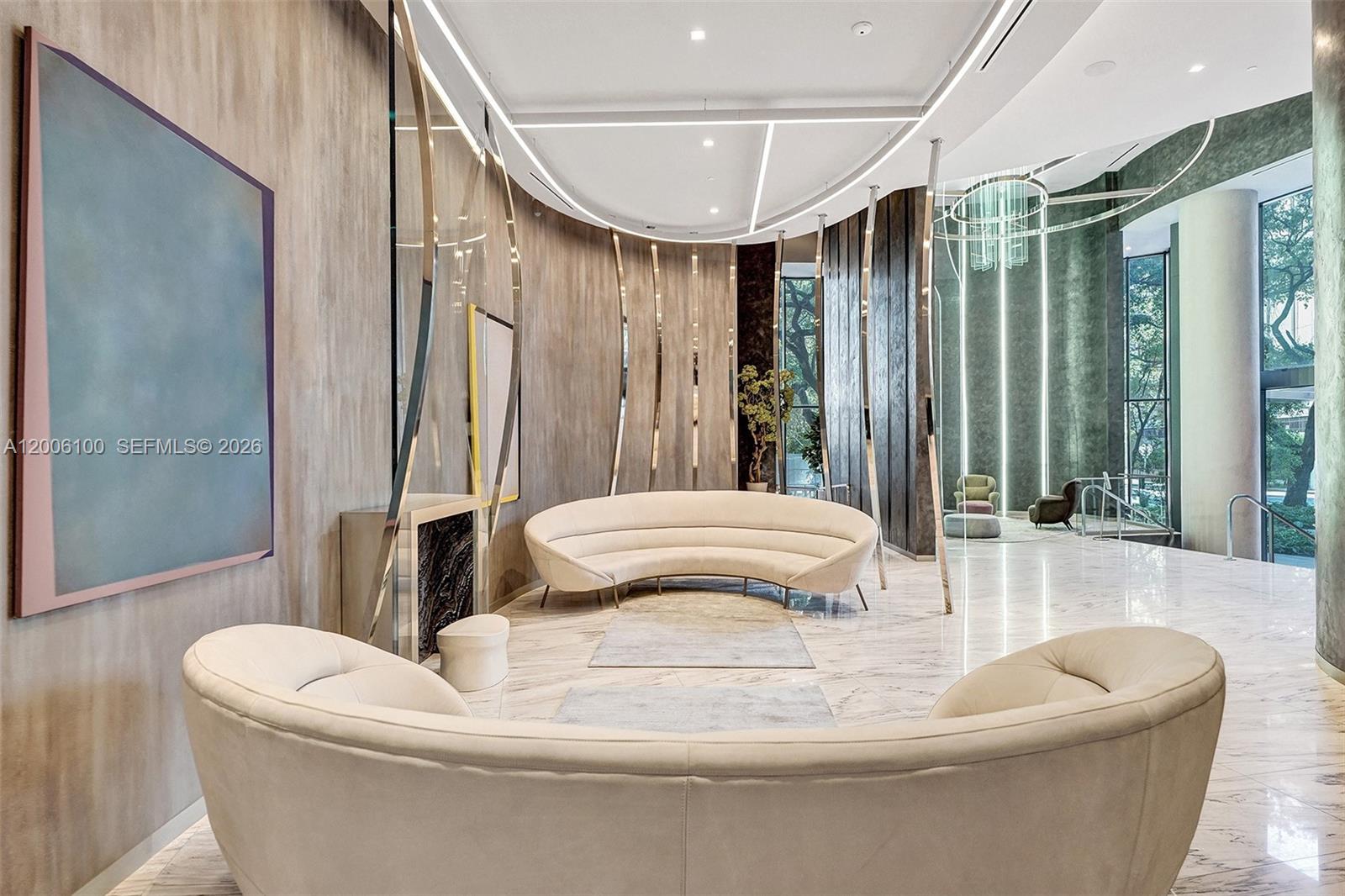 A modern lobby features curved white sofas, marble floors, and decorative metallic wall accents — 1000 Brickell Plaza, Miami FL 33131, MIAMI, FL