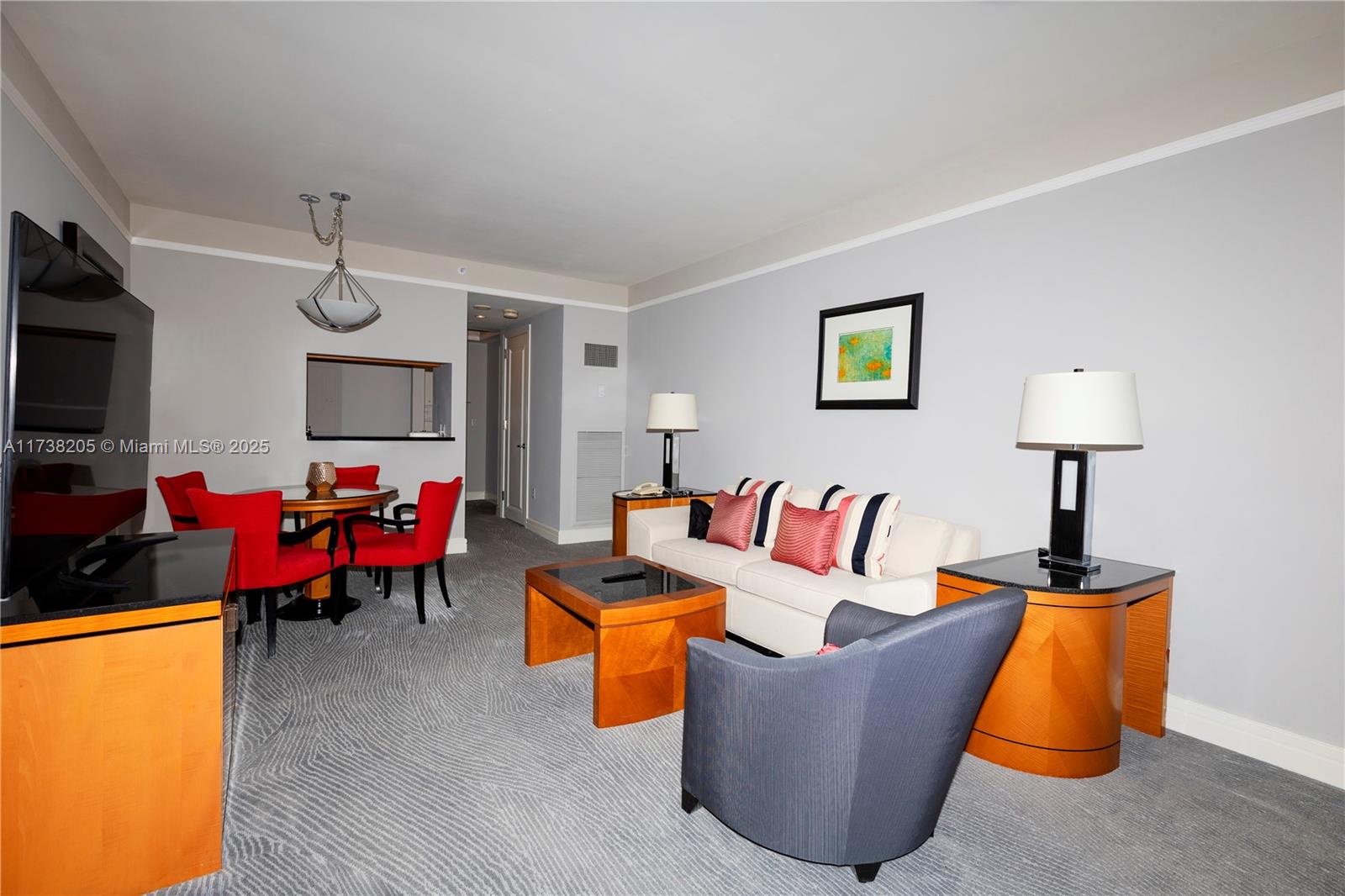A living and dining area features a sofa, armchairs, a dining table, and gray carpeting — 1435 Brickell Ave # 3010, Miami FL 33131, MIAMI, FL