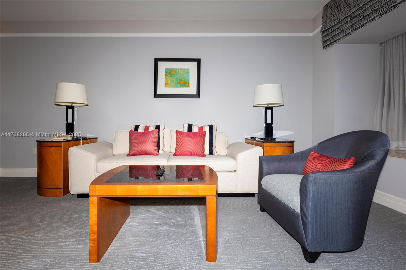 A living room features a white sofa, a dark armchair, and a wooden coffee table — 1435 Brickell Ave # 3010, Miami FL 33131, MIAMI, FL