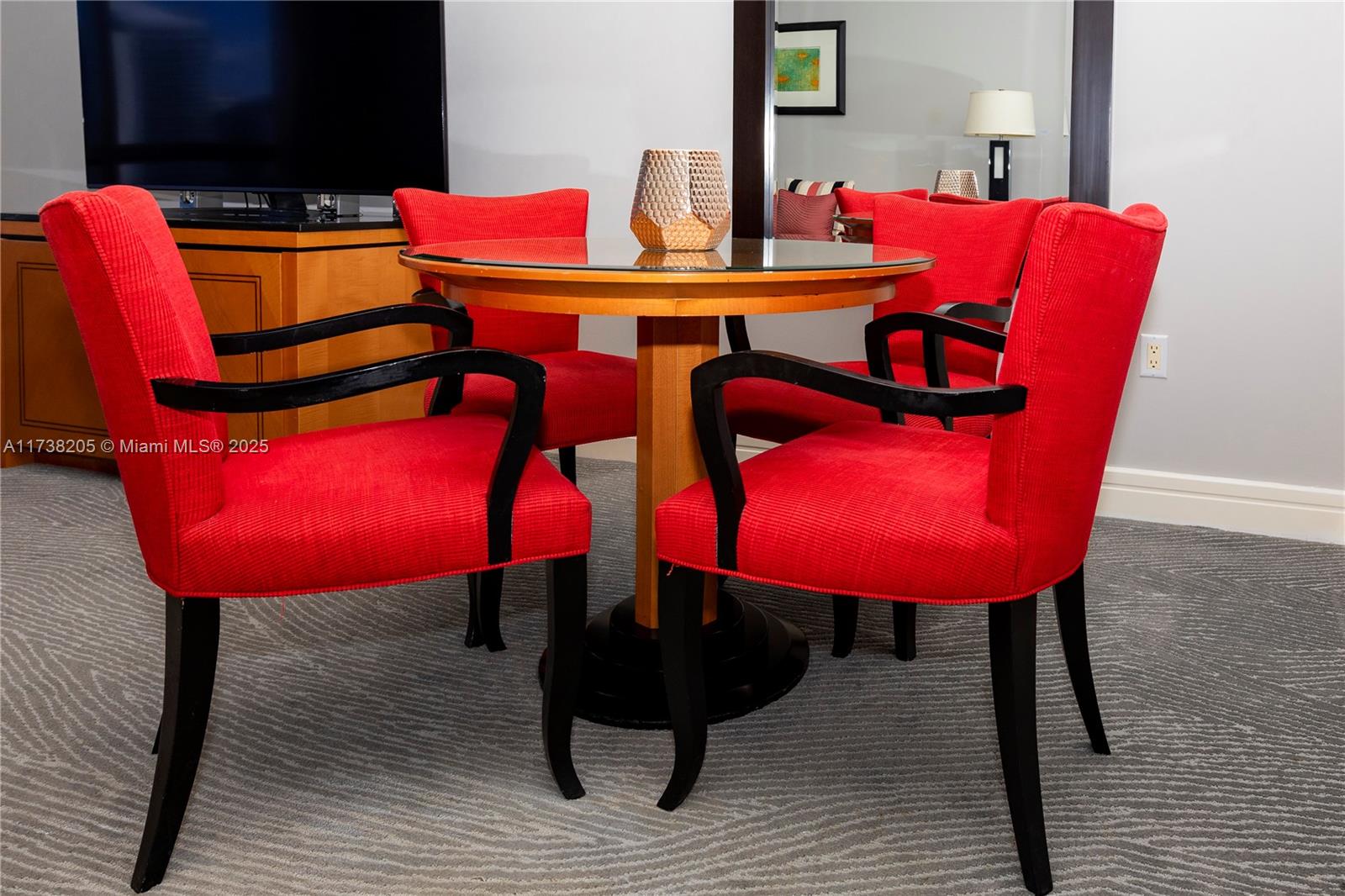 A dining area features a round glass table surrounded by four red upholstered chairs — 1435 Brickell Ave # 3010, Miami FL 33131, MIAMI, FL