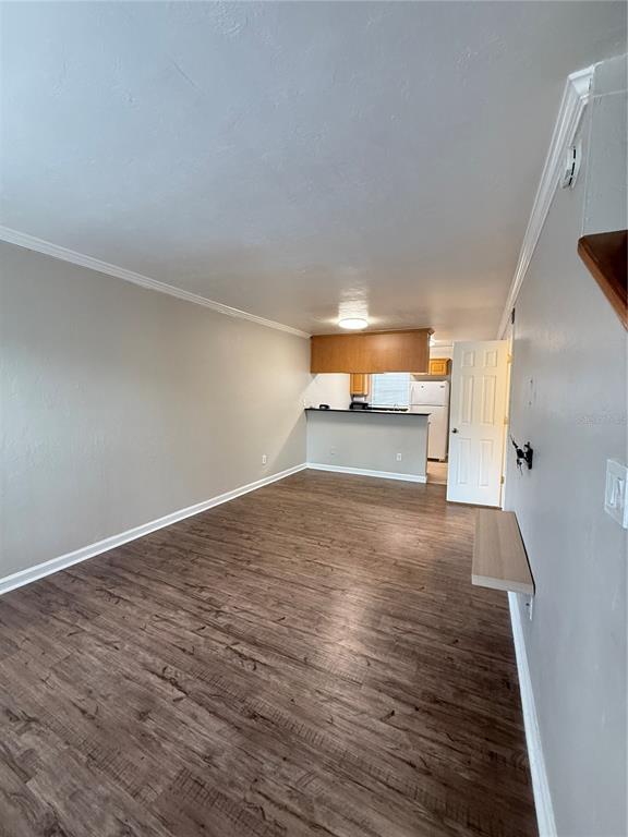 An open-concept living room with wood-look flooring leads to a kitchen with a breakfast bar — 630 SW 10TH LANE UNIT 2, GAINESVILLE, FL