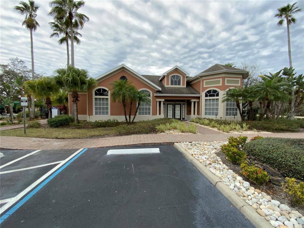 A single-story building with a tan stucco exterior, arched windows, and a paved walkway — 1999 SUMMER CLUB DRIVE UNIT 313, OVIEDO, FL