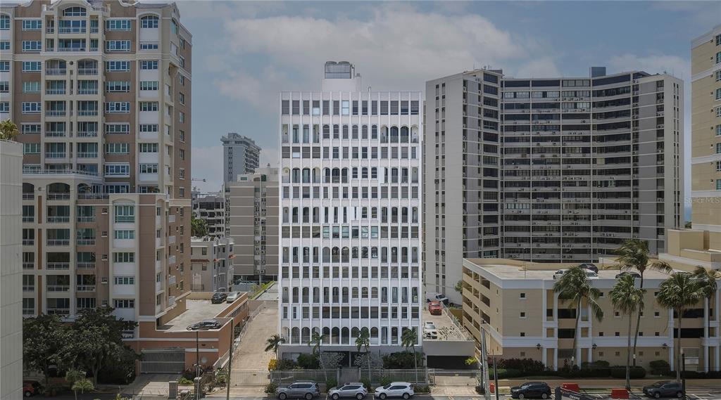 An exterior view of a tall, white residential building surrounded by other high-rise apartment complexes — 16 CARRION COURT UNIT 24, SAN JUAN, PR