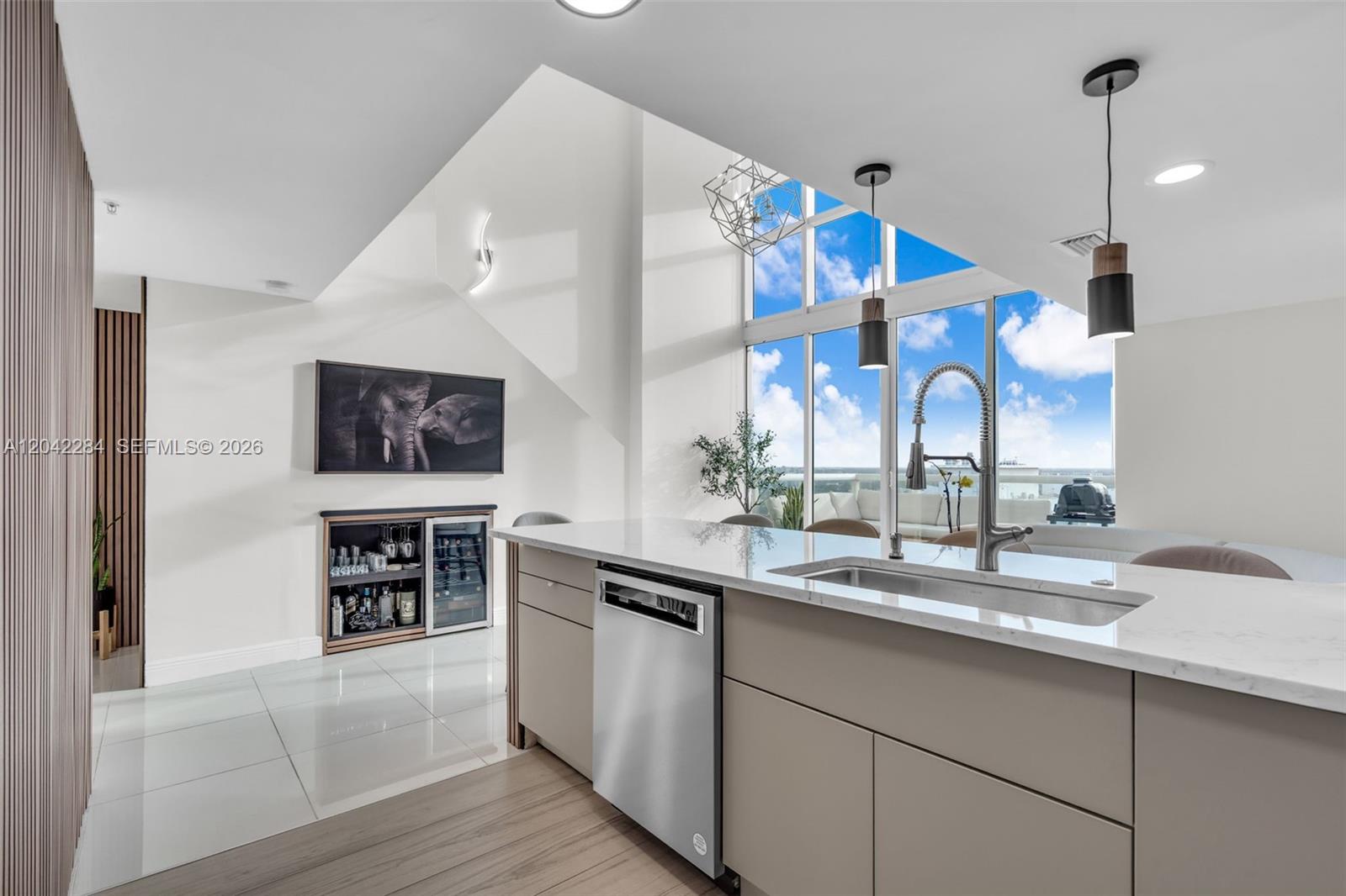 A modern kitchen features a central island with a stainless steel dishwasher and sink — 1861 NW S River Dr, Miami FL 33125, MIAMI, FL