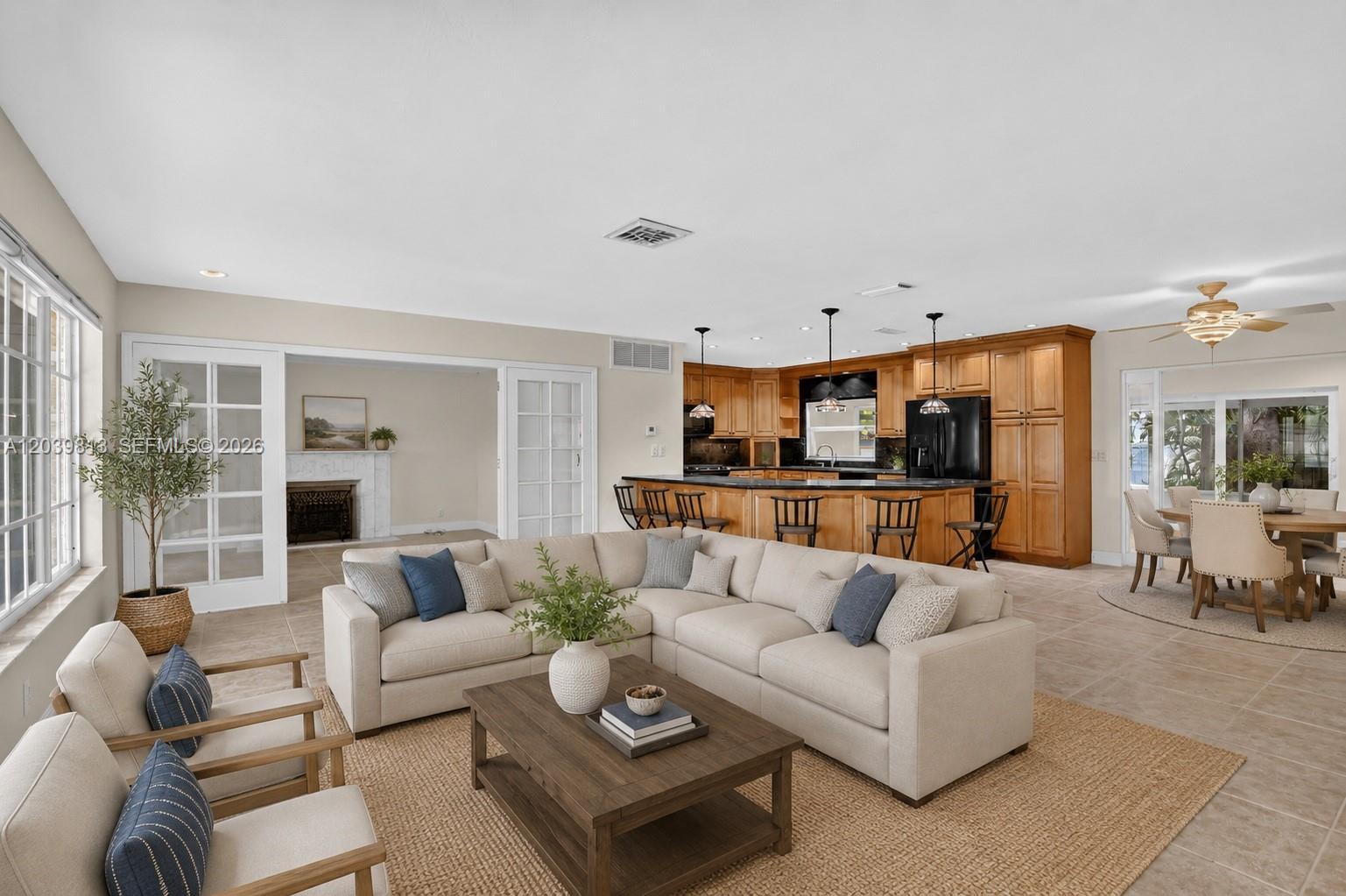 An open-concept living room features a sectional sofa, kitchen with wooden cabinets, and dining area — 5511 Taylor St, Hollywood FL 33021, HOLLYWOOD, FL