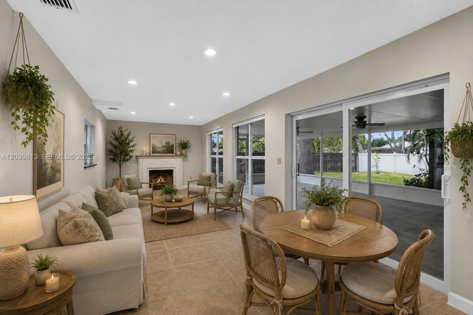 A living and dining area features a fireplace, tile floors, and sliding glass doors — 5511 Taylor St, Hollywood FL 33021, HOLLYWOOD, FL