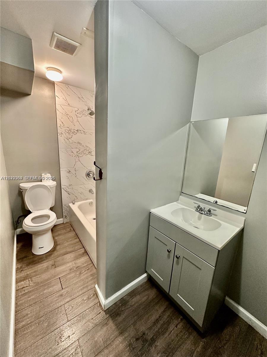 A bathroom features a vanity with a mirror, a toilet, and a tiled shower-tub combo — 6326 NW 4th Ave # 3, Miami FL 33150, MIAMI, FL