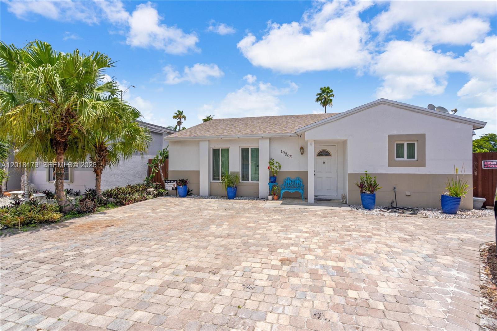 A single-story house with a paved driveway, a palm tree, and a parked SUV — 19903 NW 67th Ct, Hialeah FL 33015, HIALEAH, FL