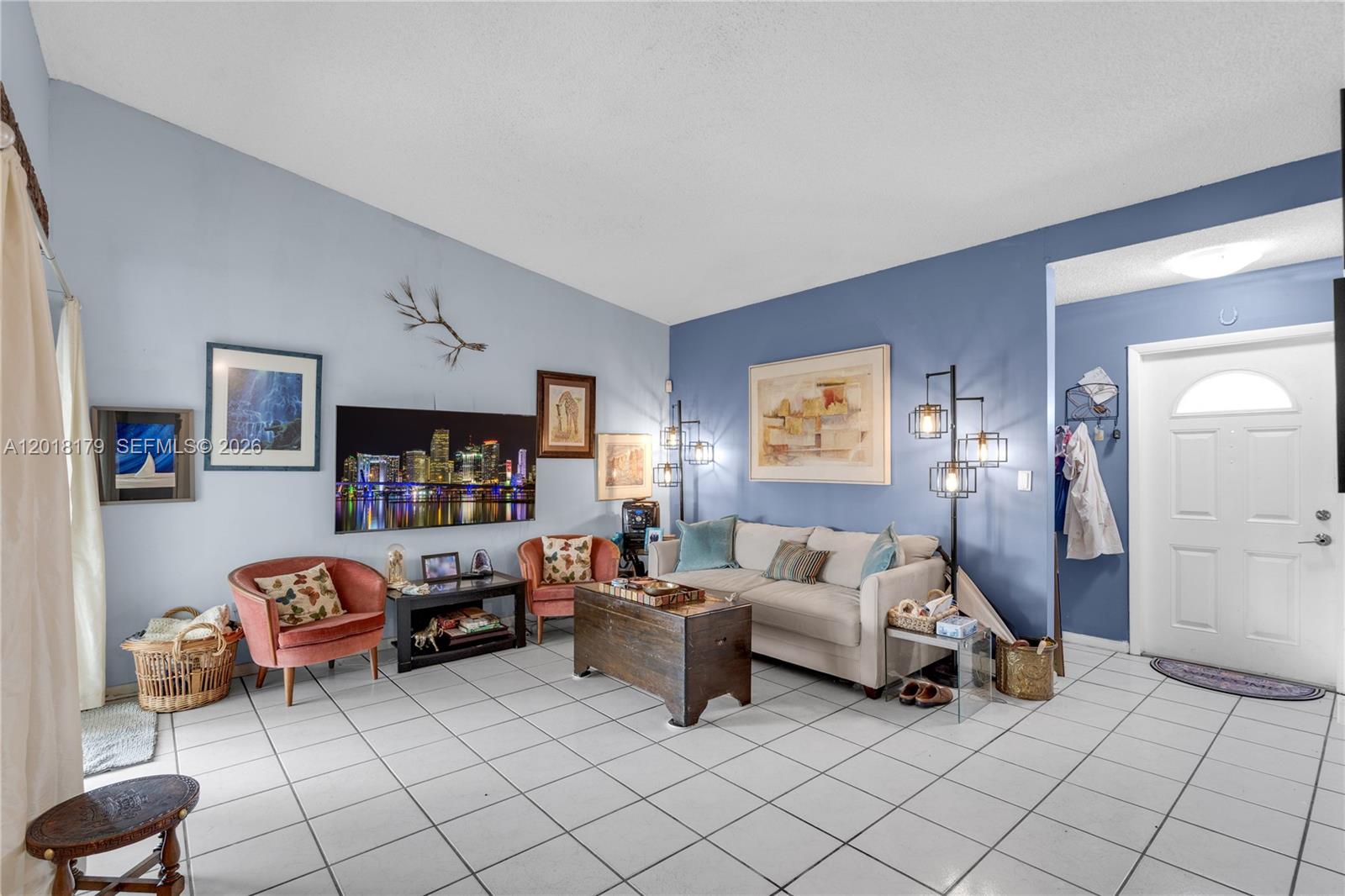 A living and dining area features white tile floors, light blue walls, and sliding glass doors — 19903 NW 67th Ct, Hialeah FL 33015, HIALEAH, FL
