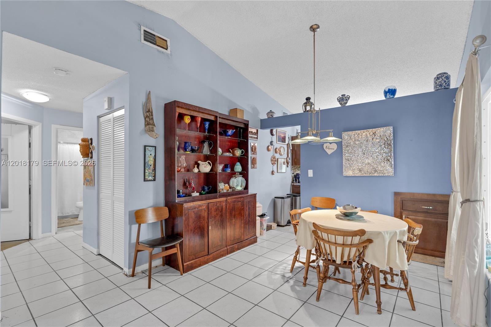A living room features light blue walls, white tile flooring, a sofa, and two armchairs — 19903 NW 67th Ct, Hialeah FL 33015, HIALEAH, FL