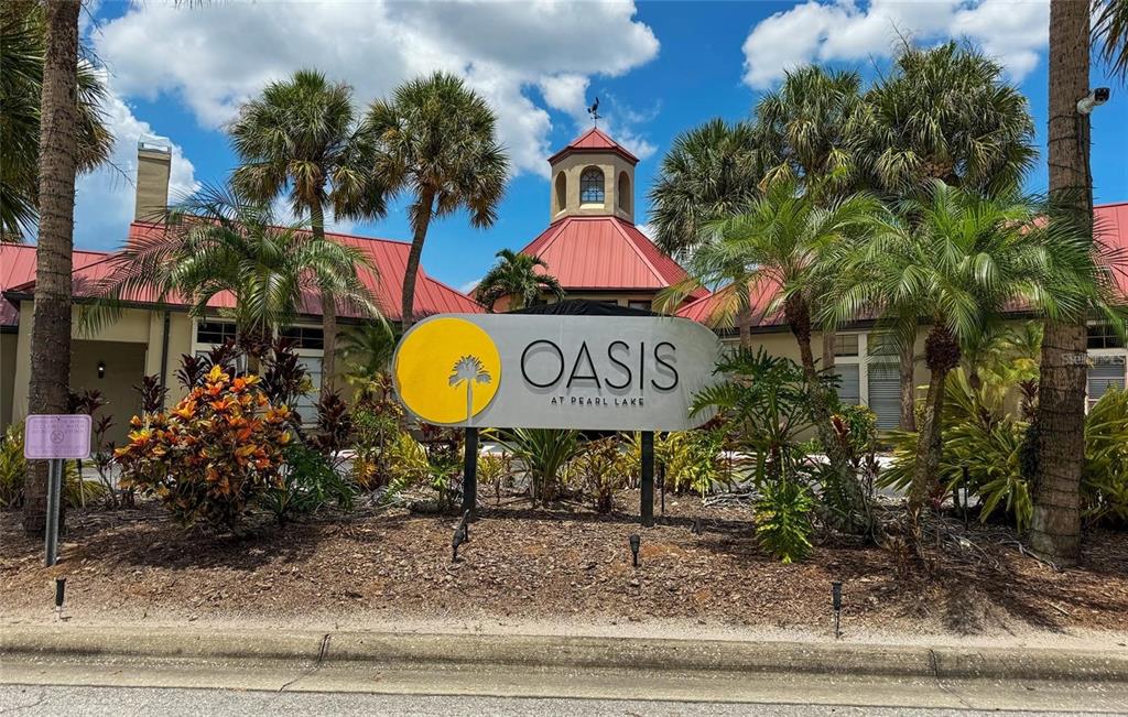 A sign for Oasis at Pearl Lake stands in front of a building with palm trees — 232 AFTON SQUARE UNIT 108, ALTAMONTE SPRINGS, FL
