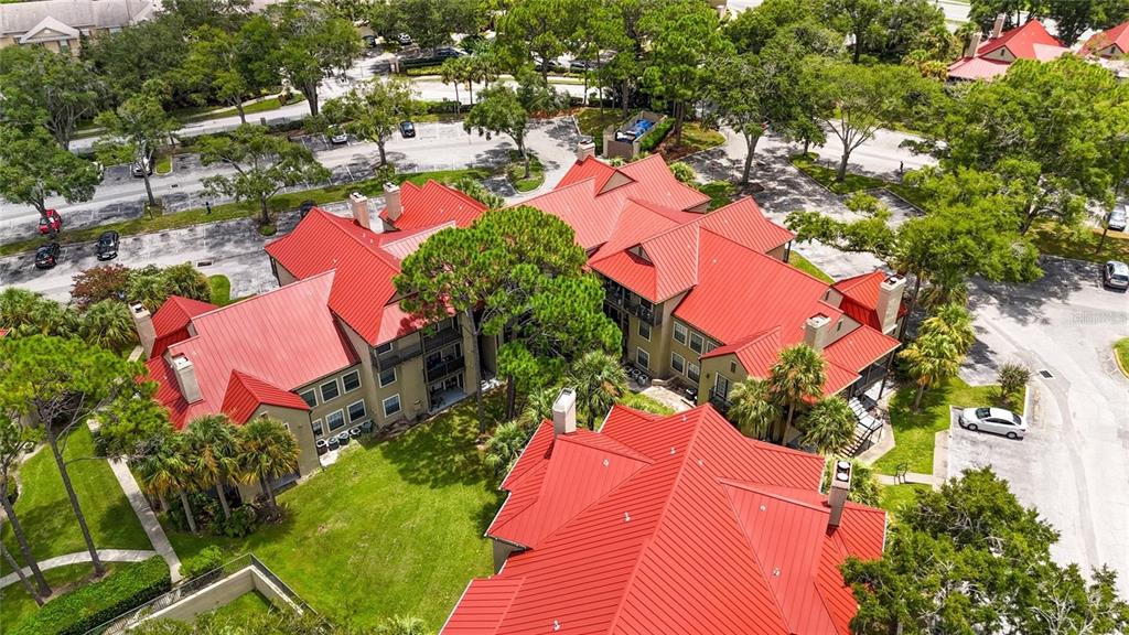 An aerial view shows a multi-story apartment complex with red metal roofs and landscaping — 232 AFTON SQUARE UNIT 108, ALTAMONTE SPRINGS, FL