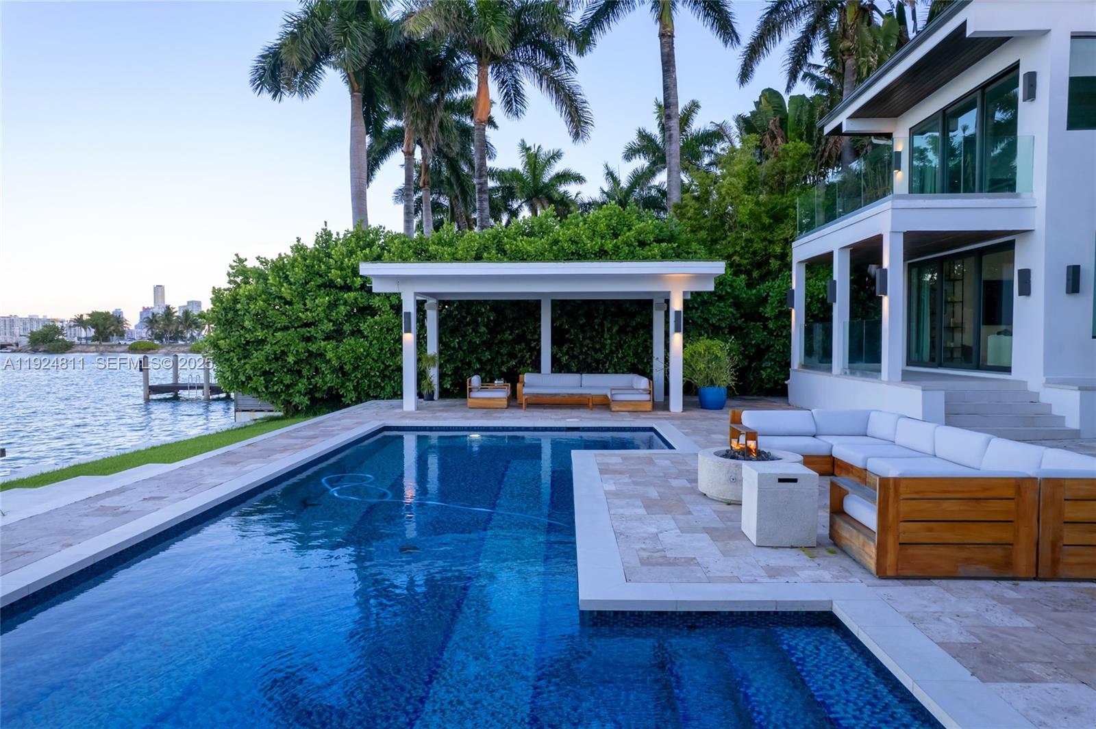 A modern house features a swimming pool, a patio with a fire pit, and a pergola — 327 E Rivo Alto Dr, Miami Beach FL 33139, MIAMI BEACH, FL