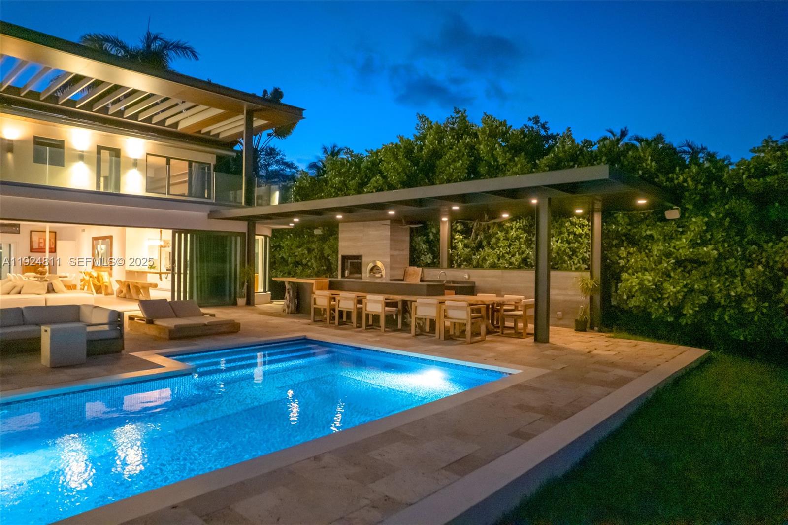 An outdoor patio features a swimming pool, a covered dining area, and a stone fireplace — 327 E Rivo Alto Dr, Miami Beach FL 33139, MIAMI BEACH, FL