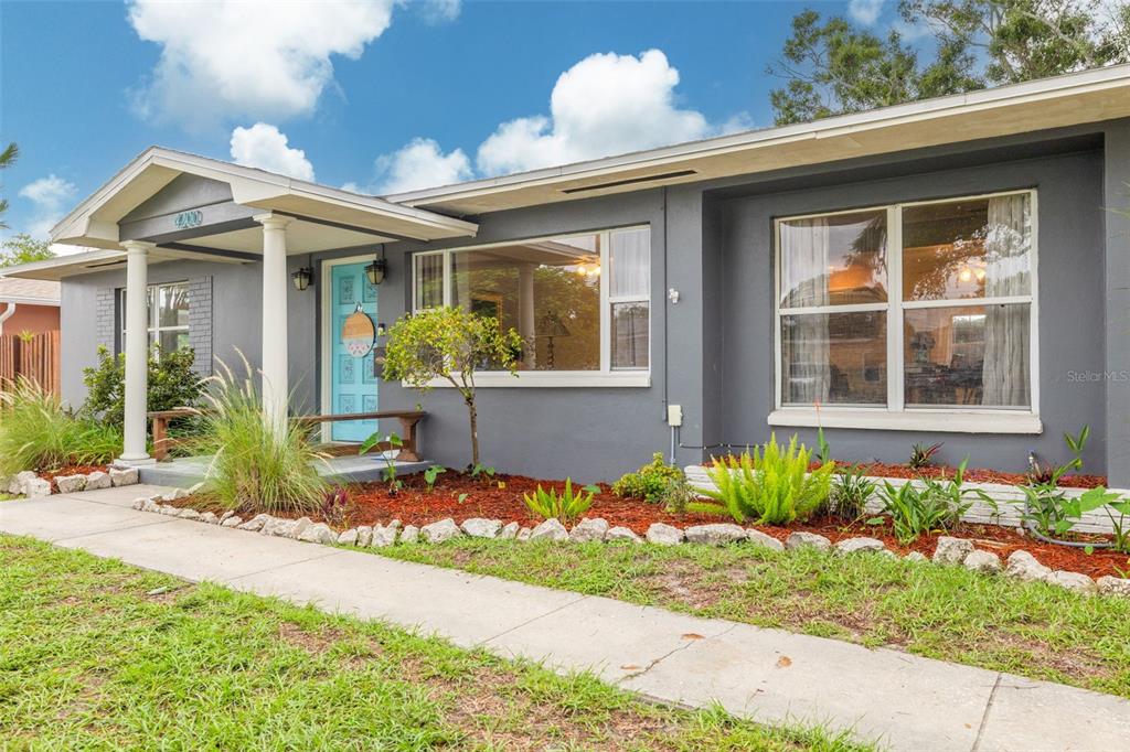 A single-story gray house with a light blue front door and a concrete walkway — 4200 29TH AVENUE N, ST PETERSBURG, FL