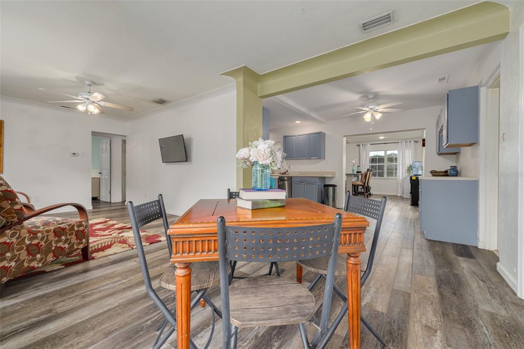 A dining area with a wooden table and chairs sits in an open-concept living space — 4200 29TH AVENUE N, ST PETERSBURG, FL