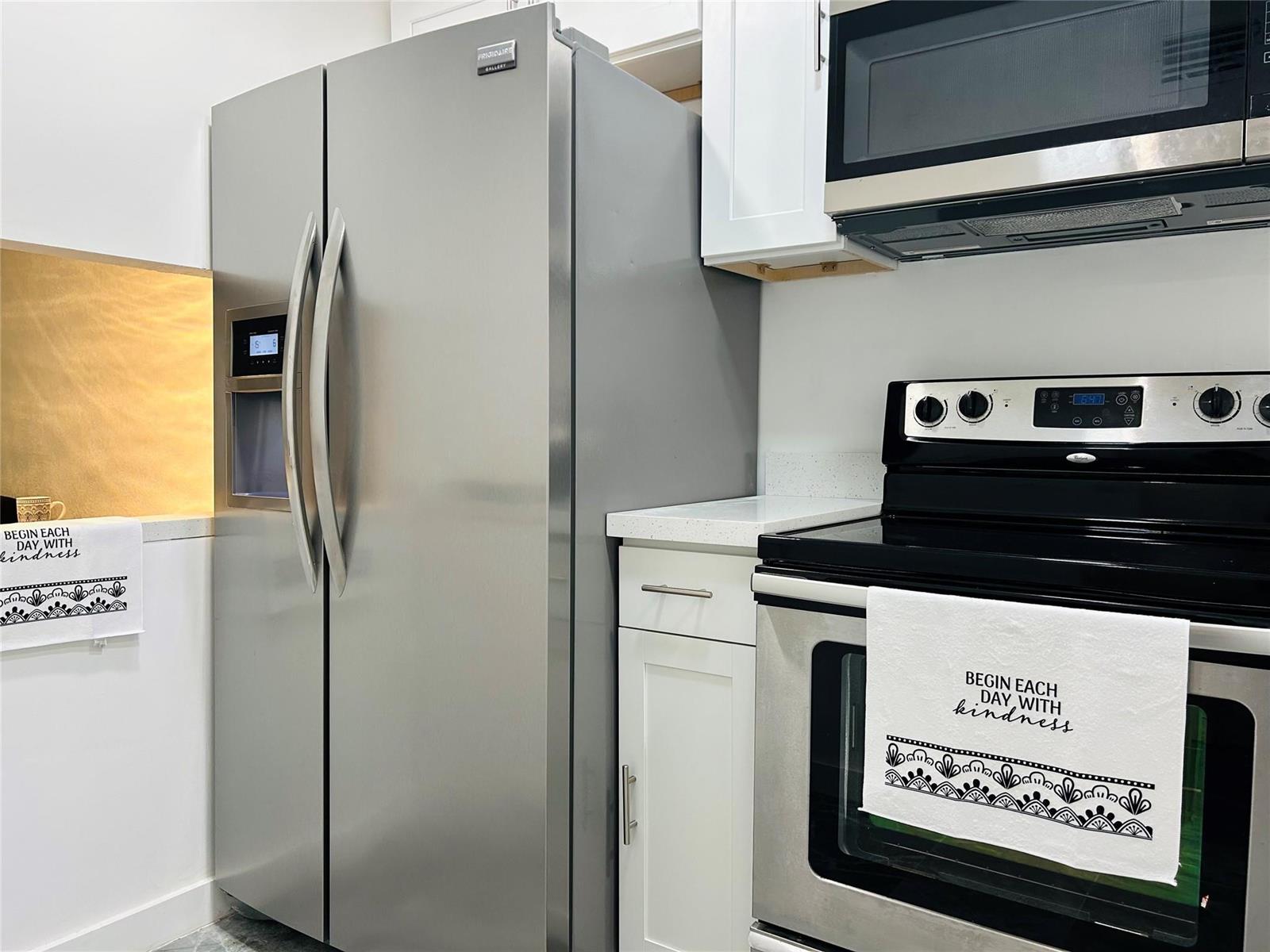 A kitchen featuring stainless steel appliances, white cabinets, and a white towel with black text — 2871 E Sunrise Lakes Drive # 101, Sunrise FL 33322, SUNRISE, FL