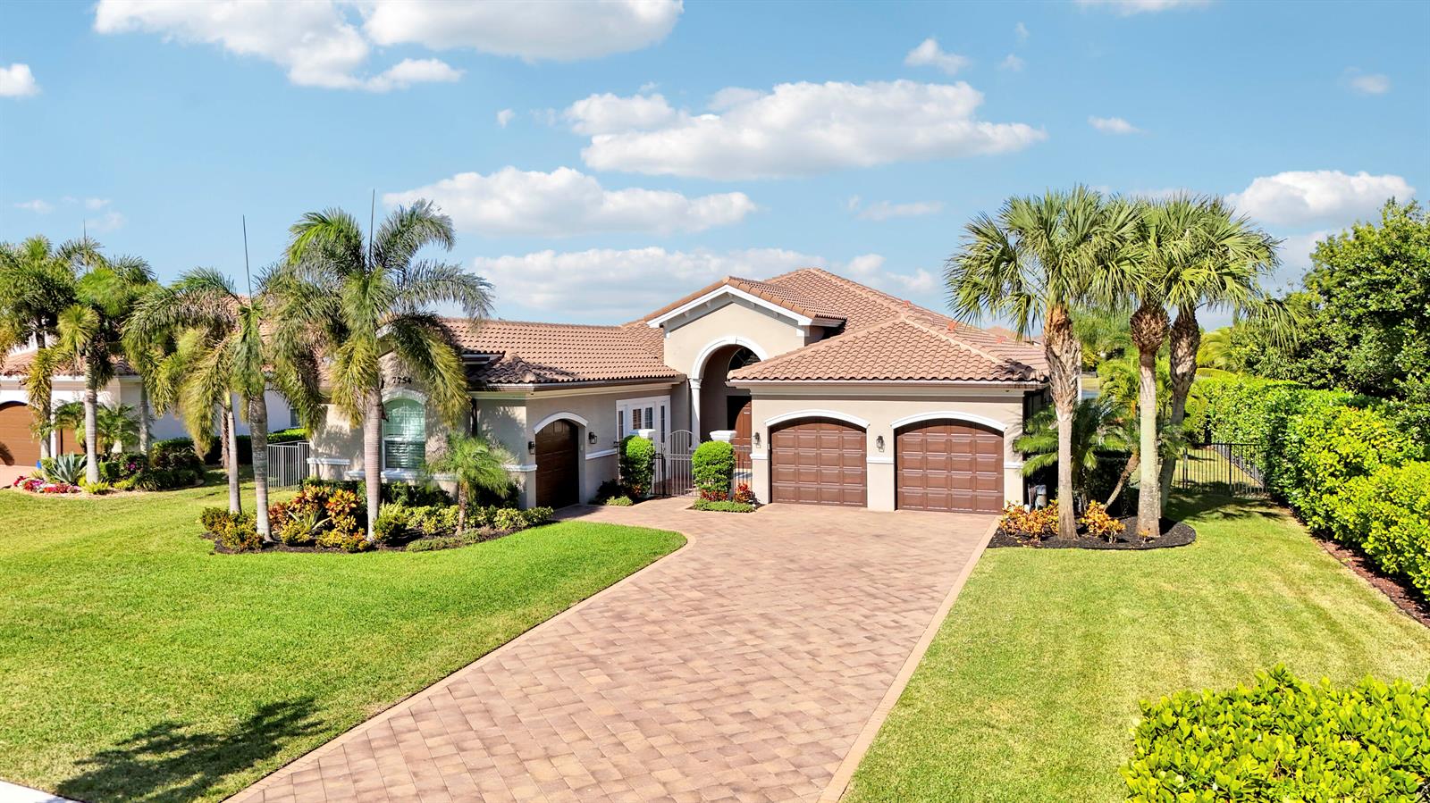 A single-story house with a tile roof, three garage doors, and a paved driveway — 7754 Maywood Crest Drive, West Palm Beach FL 33412, WEST PALM BEACH, FL