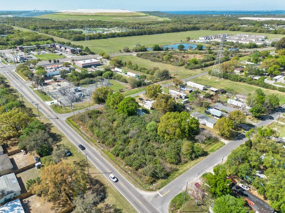 An aerial view shows a vacant, tree-covered lot situated between two paved roads — 7623 S 51ST AVENUE, TAMPA, FL