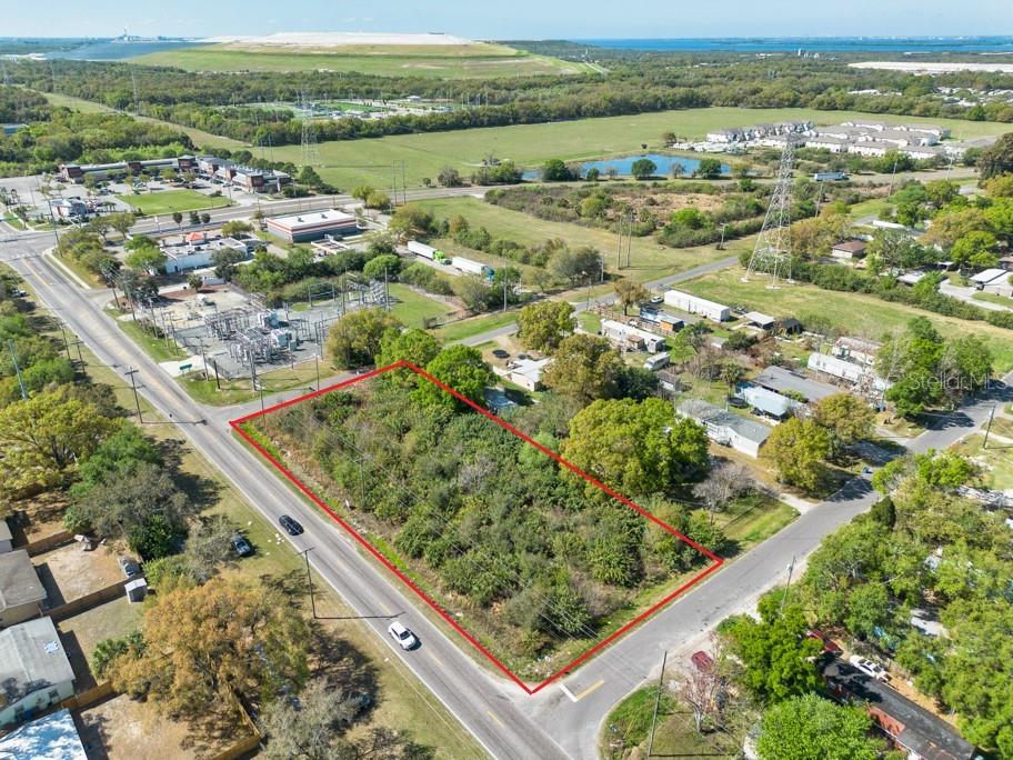 An aerial view shows a vacant, rectangular lot outlined in red along a paved road — 7623 S 51ST AVENUE, TAMPA, FL