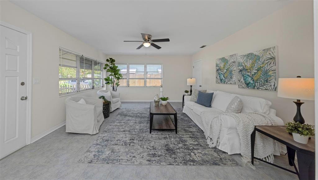 A living room features light tile floors, a white sofa, two armchairs, and a ceiling fan — 2814 TIFTON STREET S, GULFPORT, FL