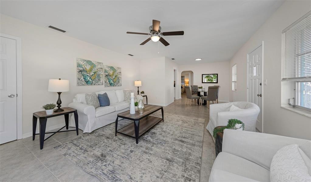 A living room with white furniture, a gray area rug, and a ceiling fan — 2814 TIFTON STREET S, GULFPORT, FL