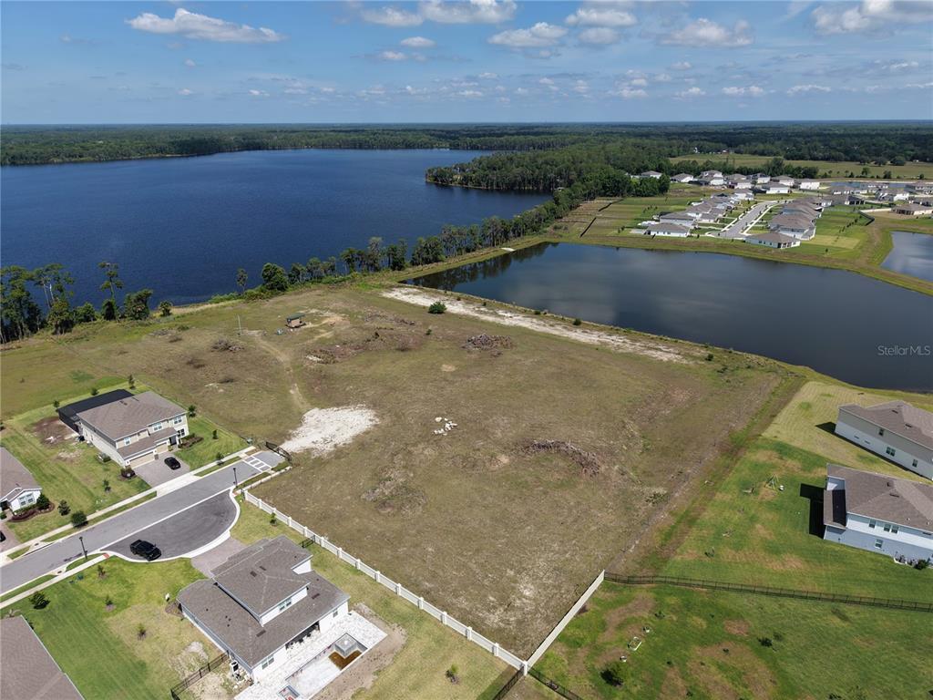 An aerial view shows a vacant residential lot situated between existing houses and a lake — LAKE PICKETT RD, ORLANDO, FL