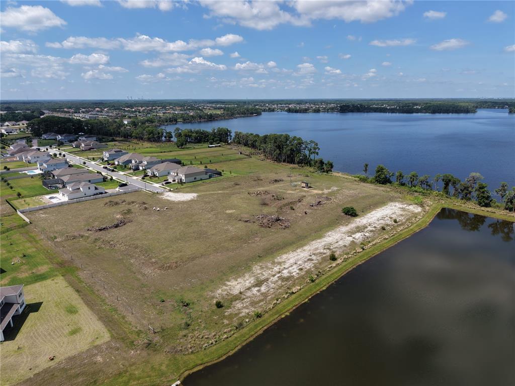 An aerial view shows a vacant grassy lot situated between a residential neighborhood and a lake — LAKE PICKETT RD, ORLANDO, FL