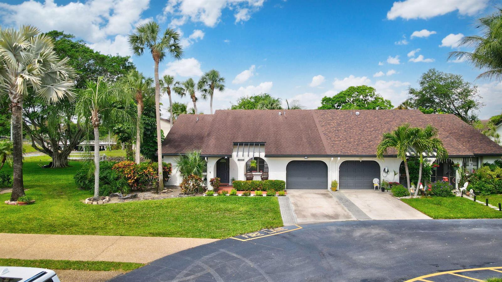 A dining area with a glass-top table and gray chairs sits before an open kitchen — 23451 SW 55th Avenue # B, Boca Raton FL 33433, BOCA RATON, FL