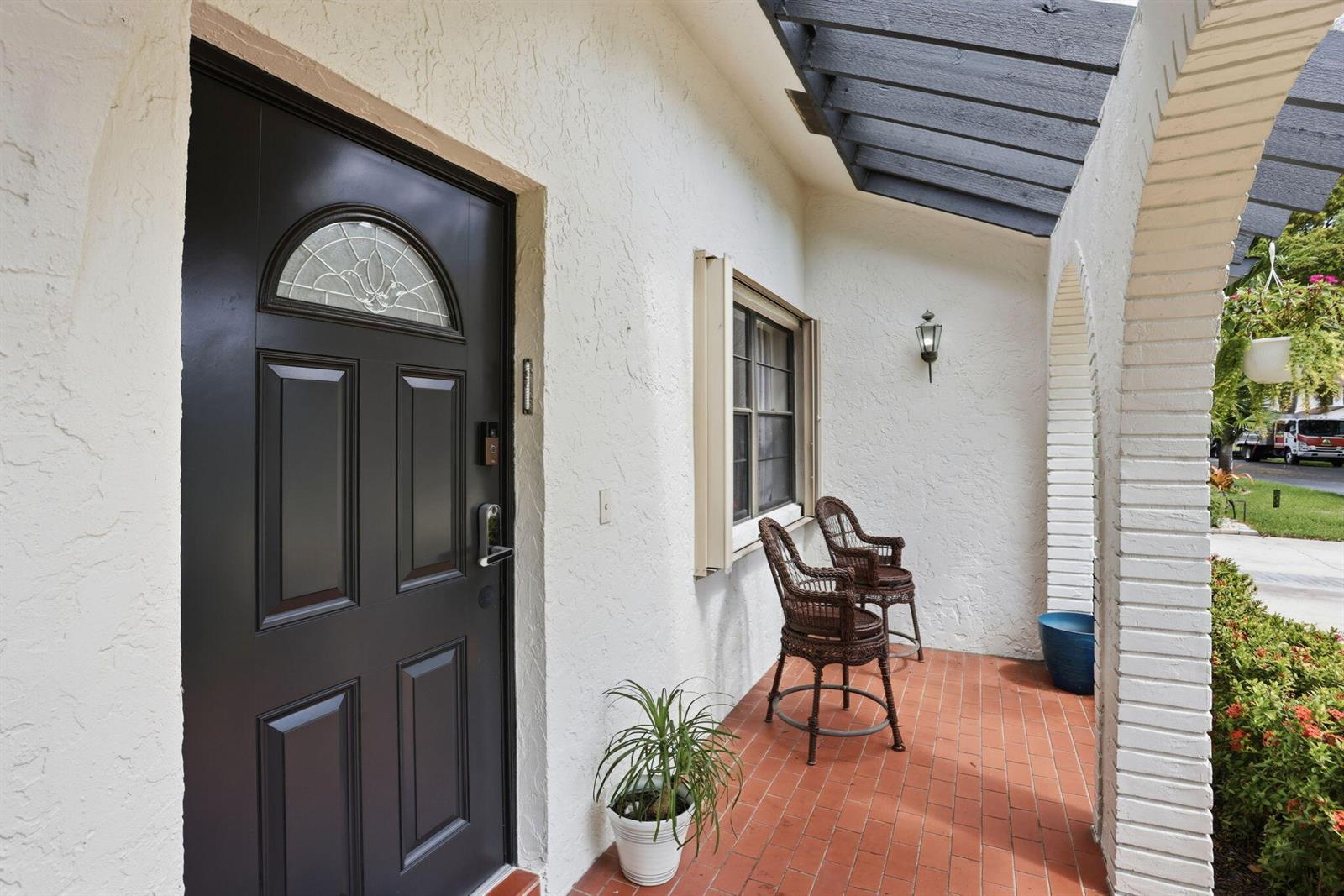 A living room with white marble floors, a wall-mounted television, and sliding glass patio doors — 23451 SW 55th Avenue # B, Boca Raton FL 33433, BOCA RATON, FL