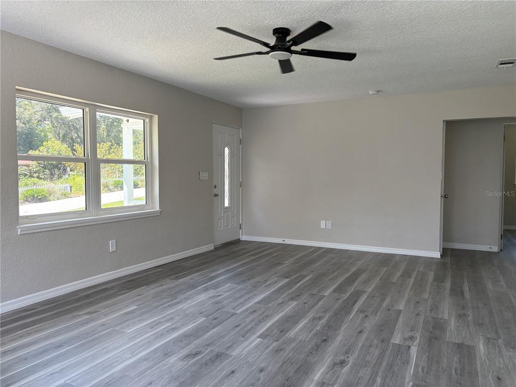 A dining area with a round table and chairs sits adjacent to a white kitchen — 2094 PENN DRIVE, DELAND, FL